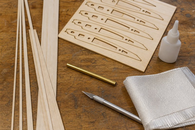 Verschiedene Modellbau-Materialien: Balsaholz, Sperrholz, Messingrohr